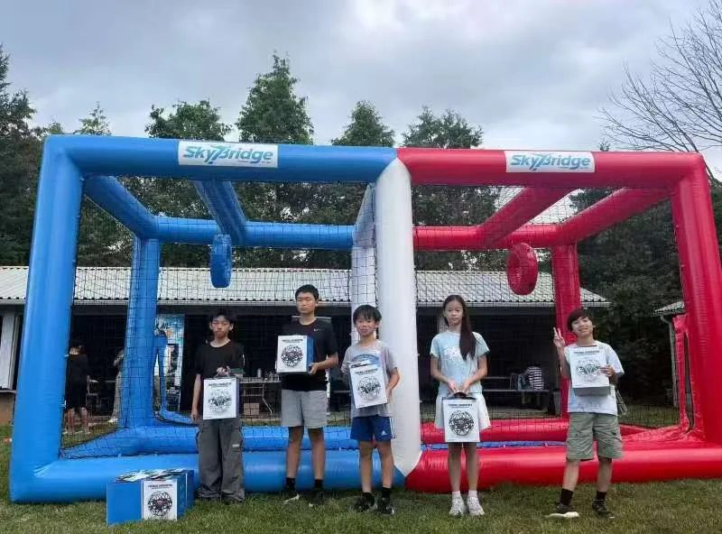 Young participants with prizes in front of a SkyBridge drone soccer arena