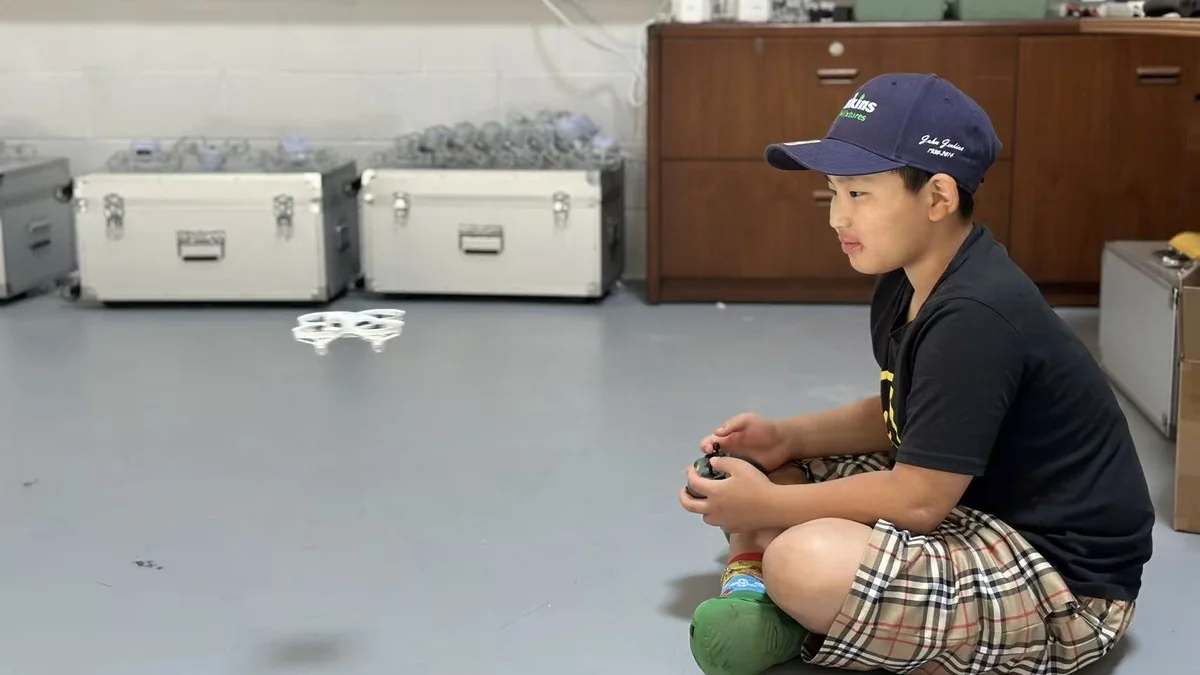 Student practicing drone control indoors